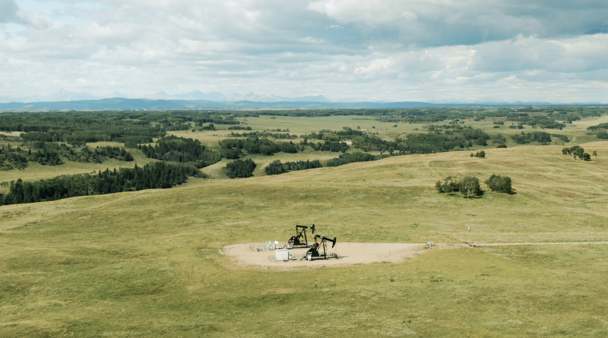 Spartan Delta operating landscape with pumpjacks and Alberta foothills